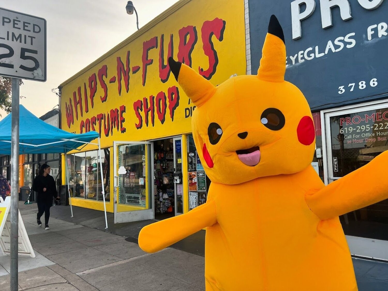 The bright yellow Whips 'n Furs storefront on 30th Street with its hand-painted red sign and a Pikachu mascot greeting people out front